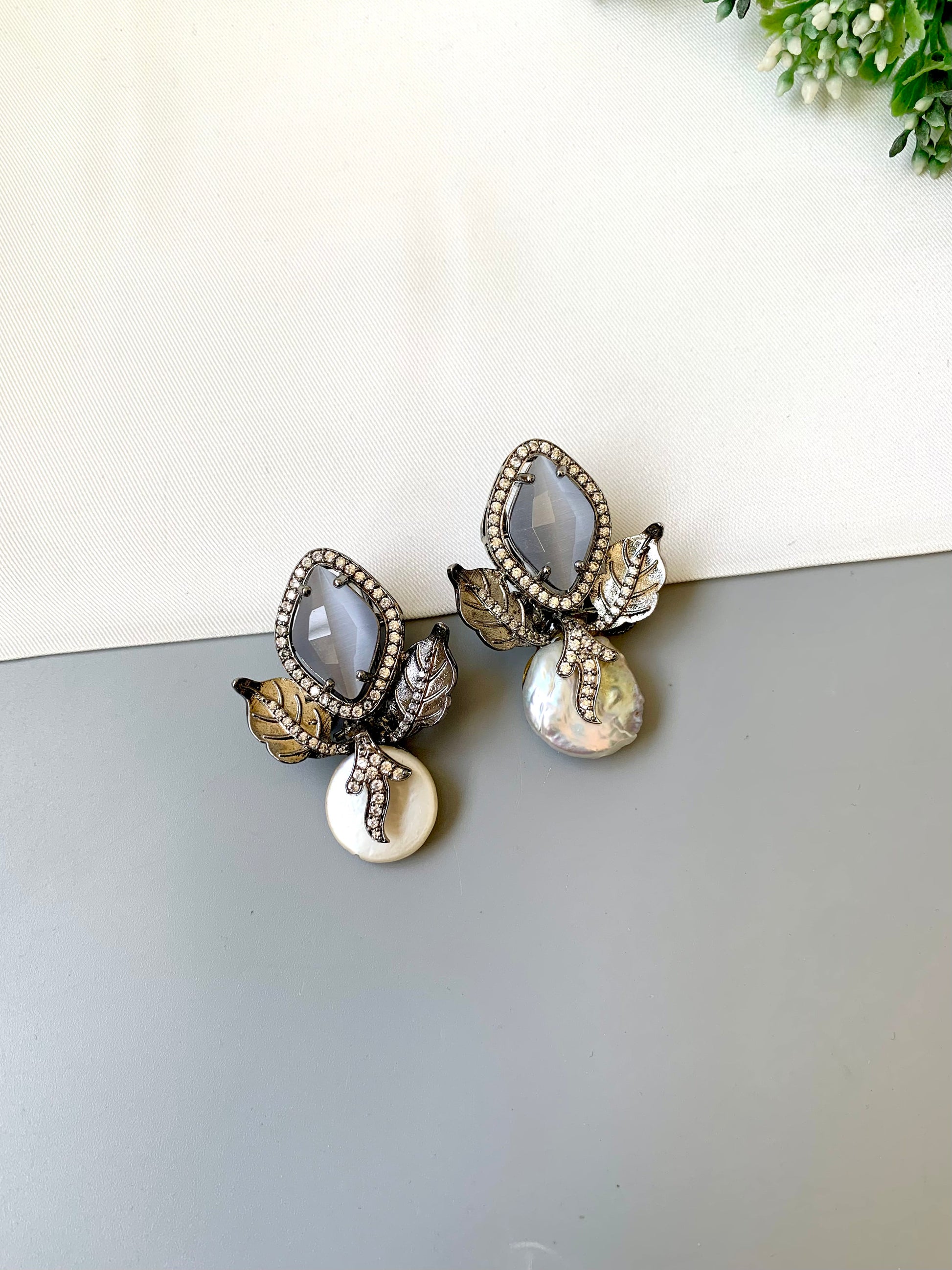 Usha grey baroque pearl studs in rhodium foil finish with onyx and american diamonds