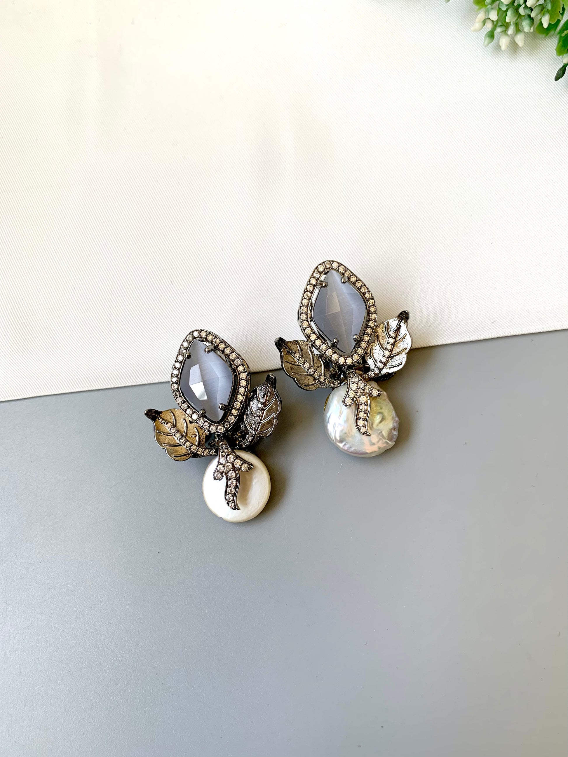 Usha grey baroque pearl studs in rhodium foil finish with onyx and american diamonds