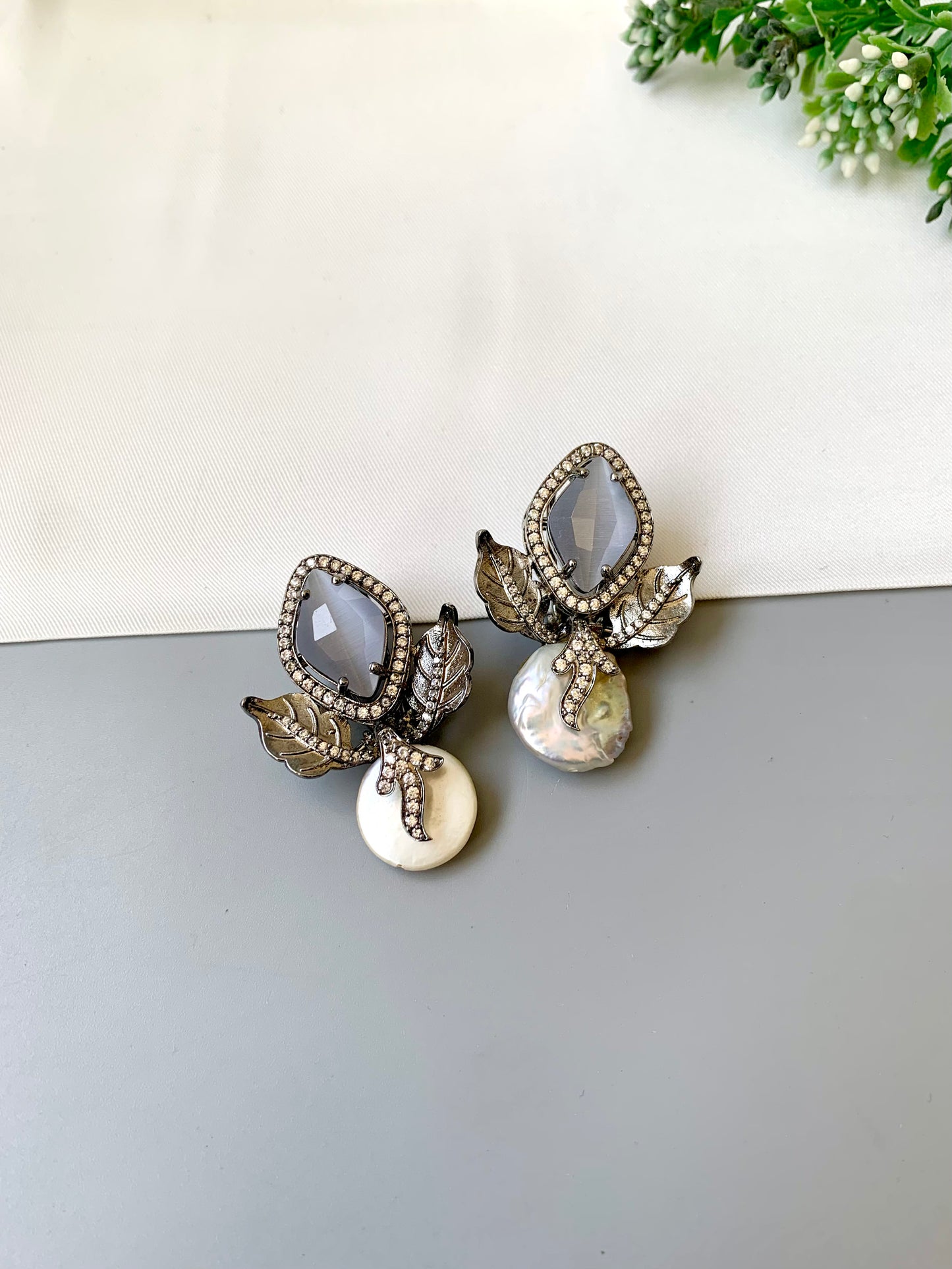 Usha grey baroque pearl studs in rhodium foil finish with onyx and american diamonds