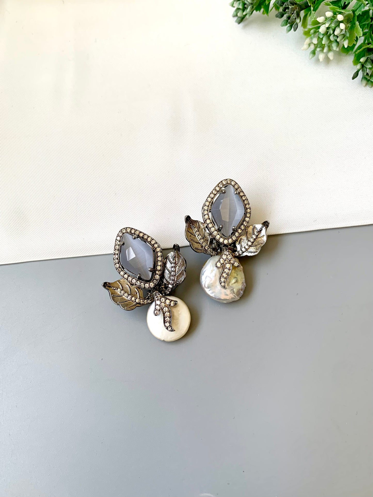 Usha grey baroque pearl studs in rhodium foil finish with onyx and american diamonds