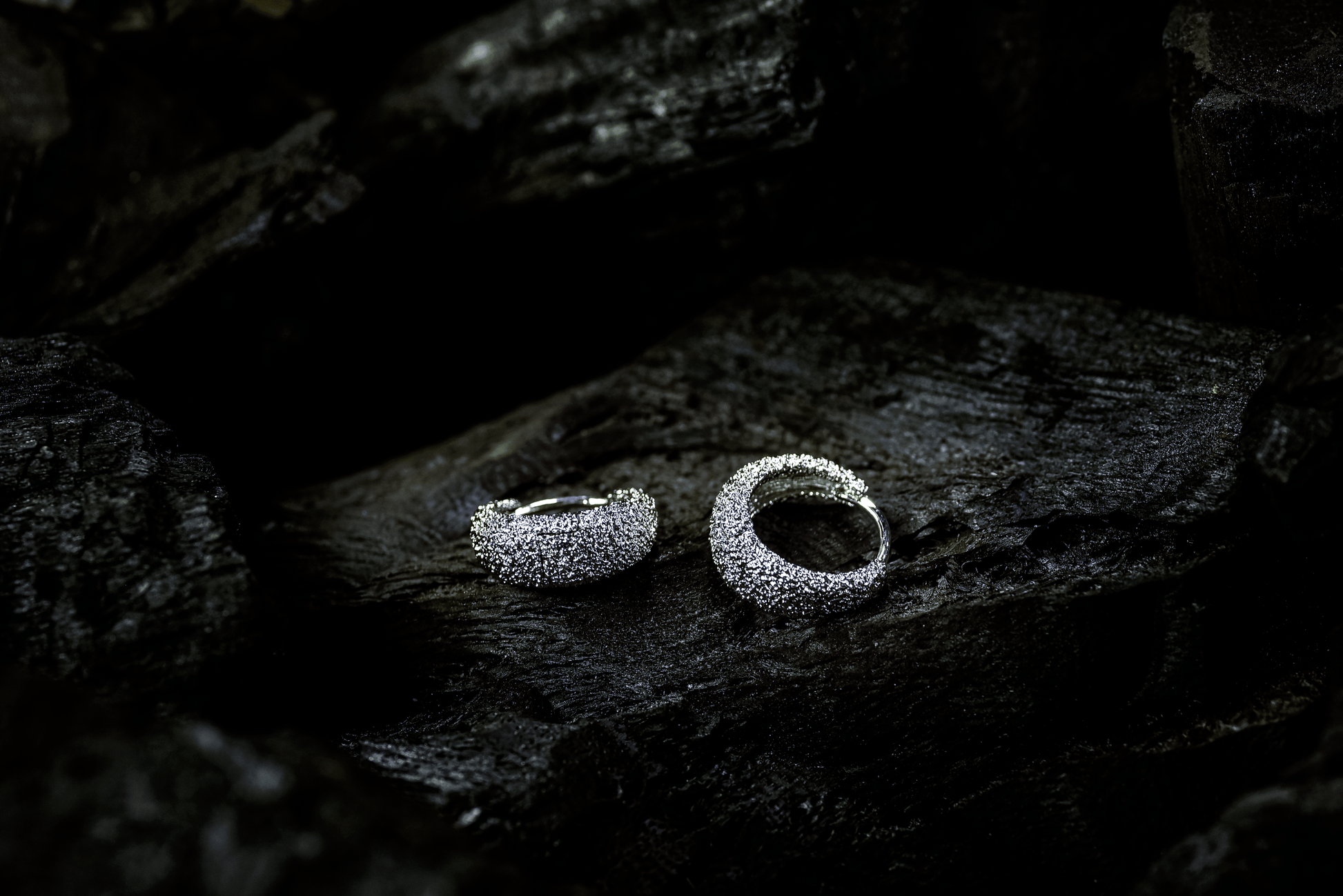 Handcrafted Venice Hoops with textured Rhodium plating in platinum finish displayed on a dark background