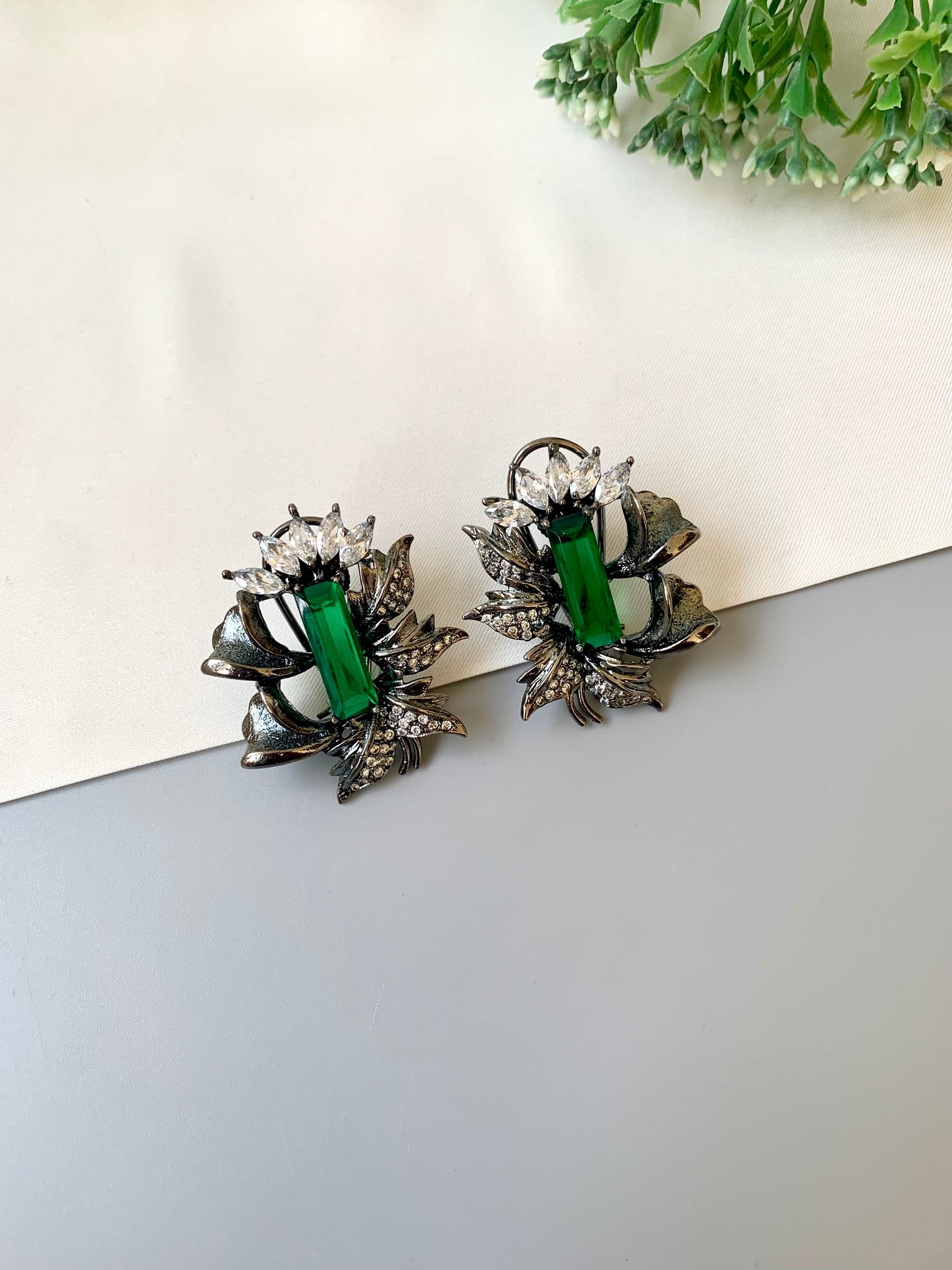 Handcrafted rhodium-plated studs with American Diamonds and semi-precious emerald