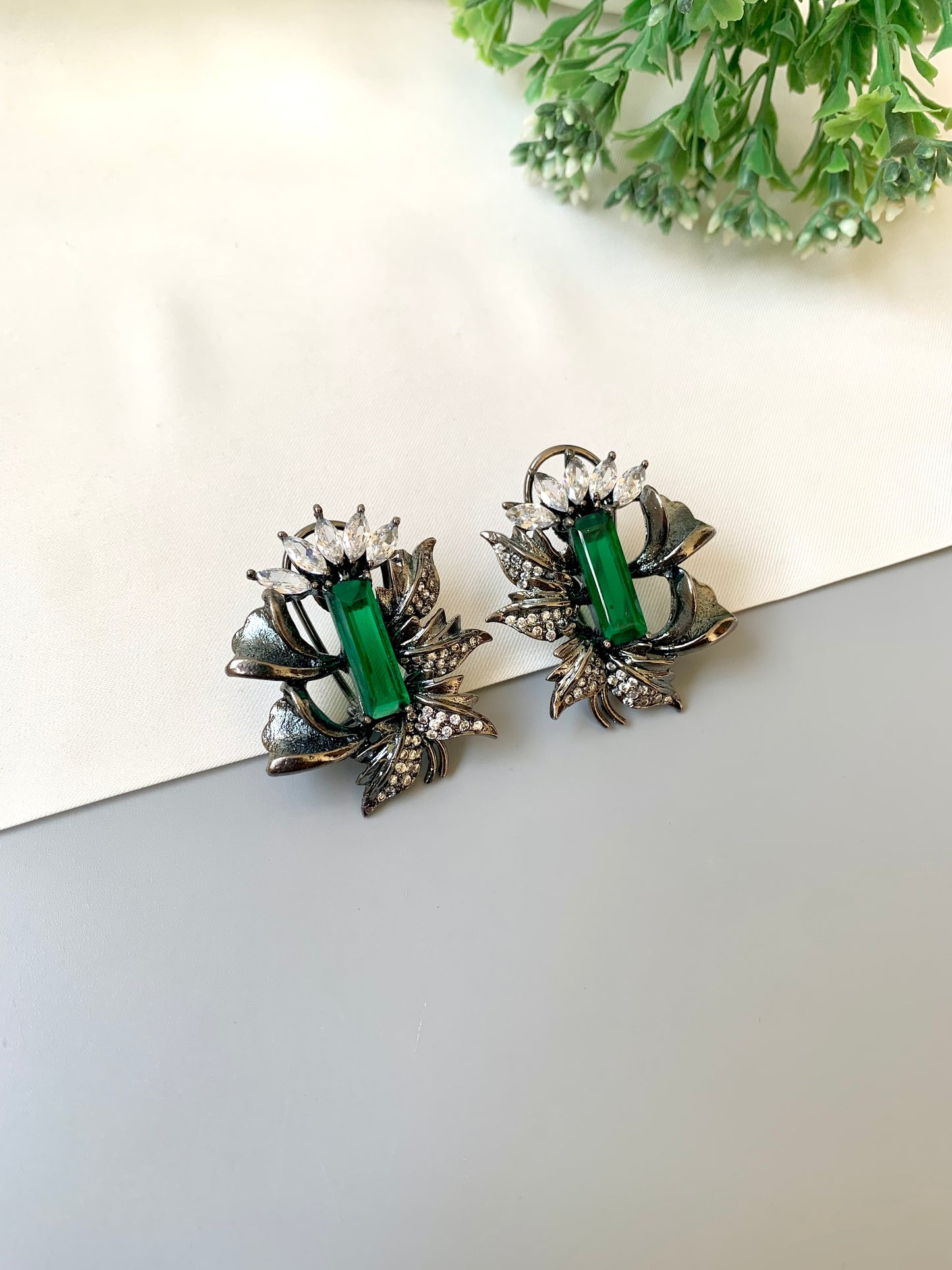 Handcrafted rhodium-plated studs with American Diamonds and semi-precious emerald