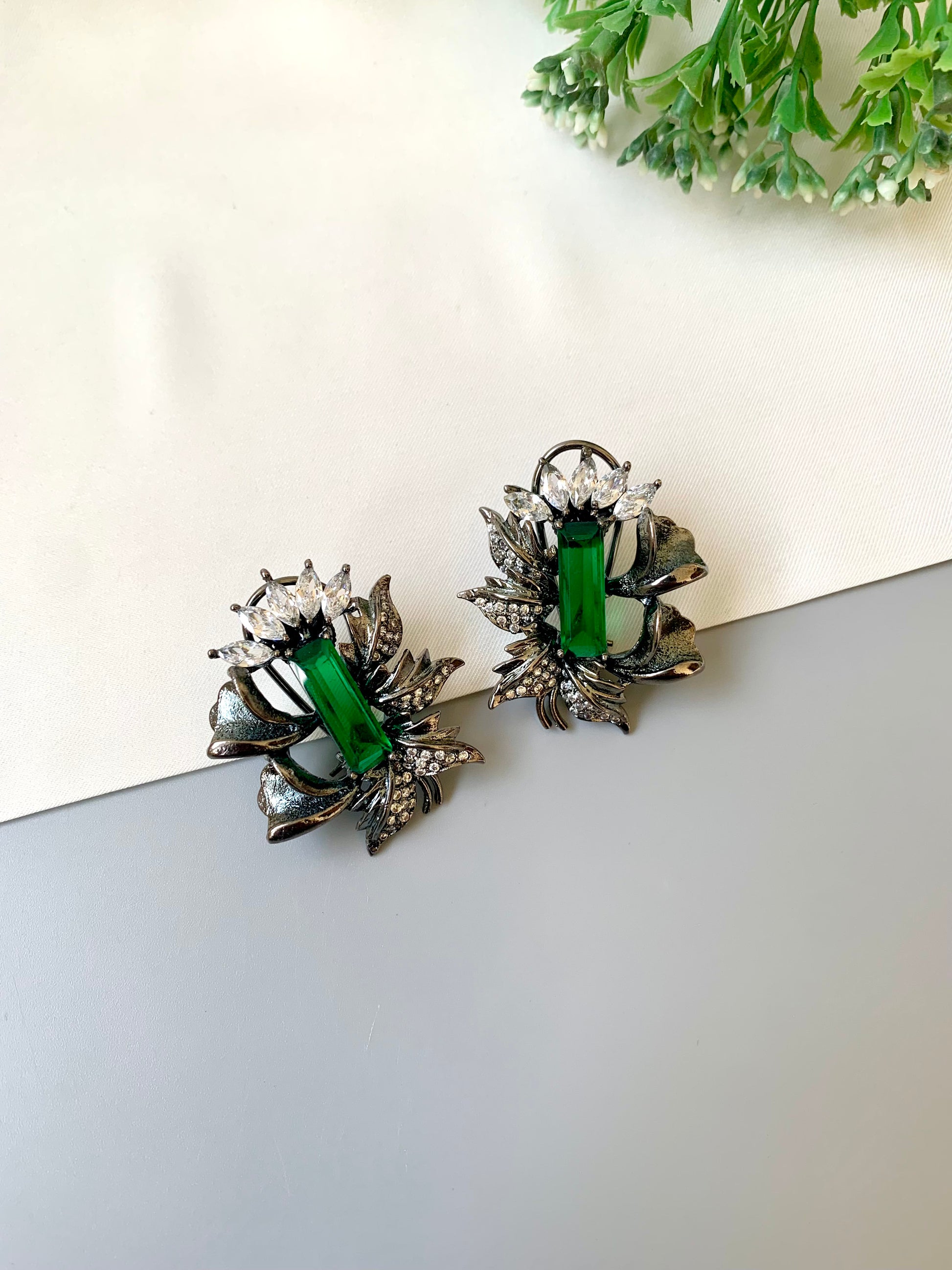 Handcrafted rhodium-plated studs with American Diamonds and semi-precious emerald