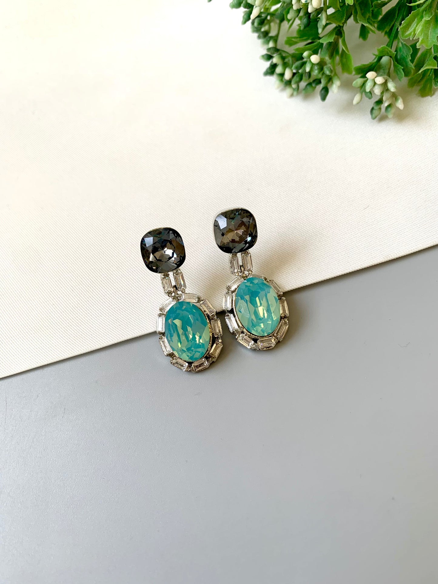 Handcrafted rhodium plated platinum finish earrings with baguette stones and Swarovski crystals in ferozi shade