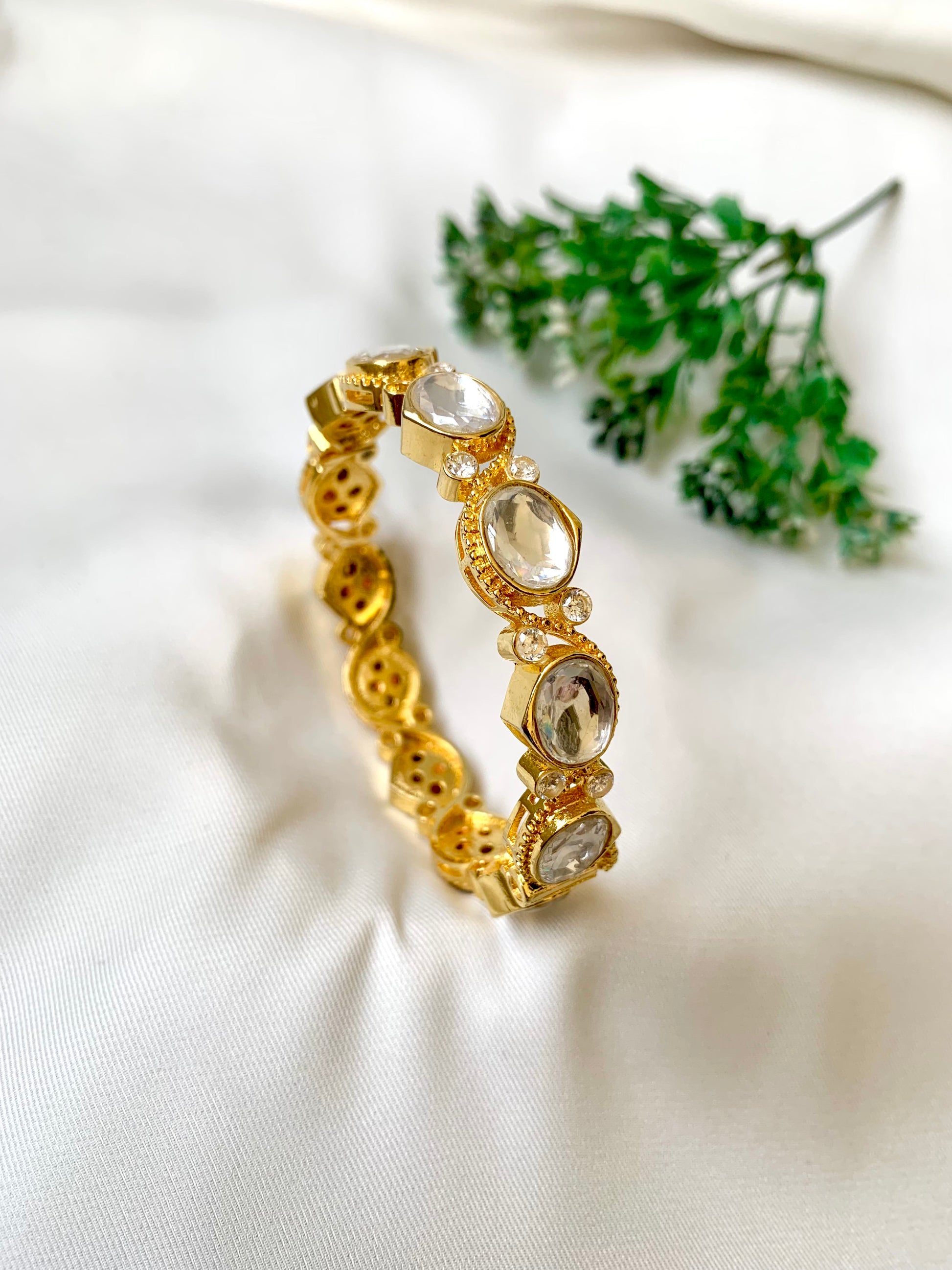 Handcrafted Arwah Bangle in 22kt gold plating with high-quality Moissanite Kundan stones and screw opening — by Zamal Jewels.