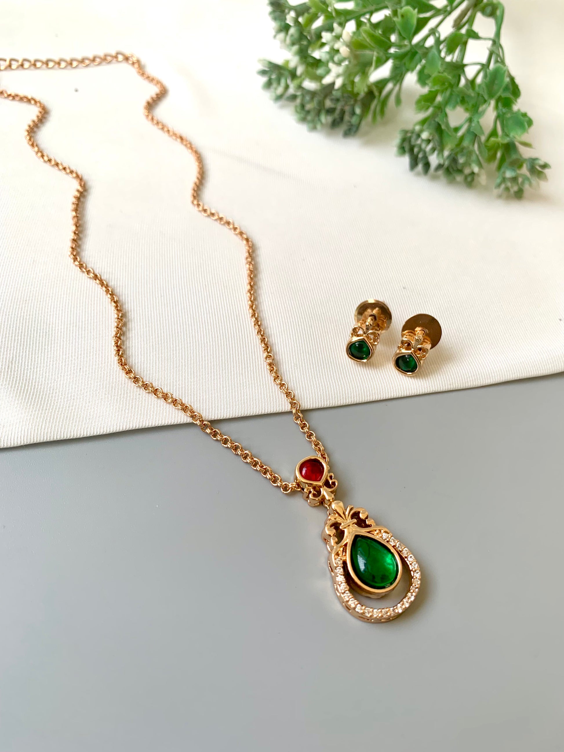 Handcrafted Lyana Pendant Set in 22kt Victorian rose gold plating with Semi-Precious Ruby, Emerald, and American Diamonds — includes chain, pendant, and studs by Zamal Jewels.
