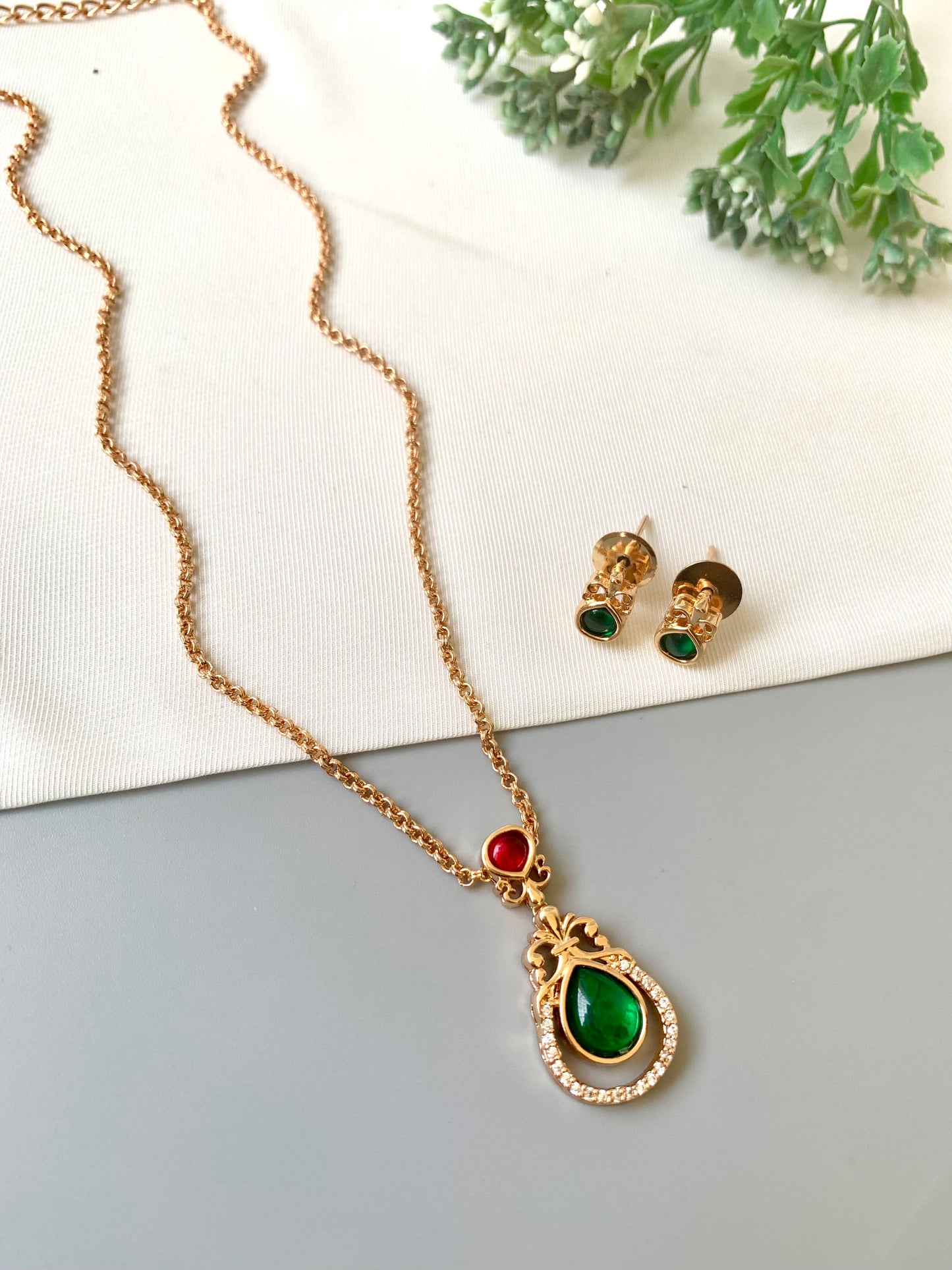Handcrafted Lyana Pendant Set in 22kt Victorian rose gold plating with Semi-Precious Ruby, Emerald, and American Diamonds — includes chain, pendant, and studs by Zamal Jewels.