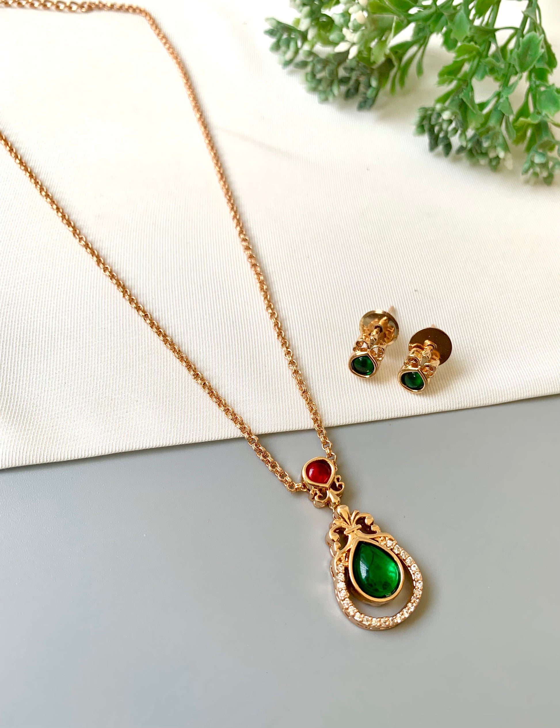 Handcrafted Lyana Pendant Set in 22kt Victorian rose gold plating with Semi-Precious Ruby, Emerald, and American Diamonds — includes chain, pendant, and studs by Zamal Jewels.