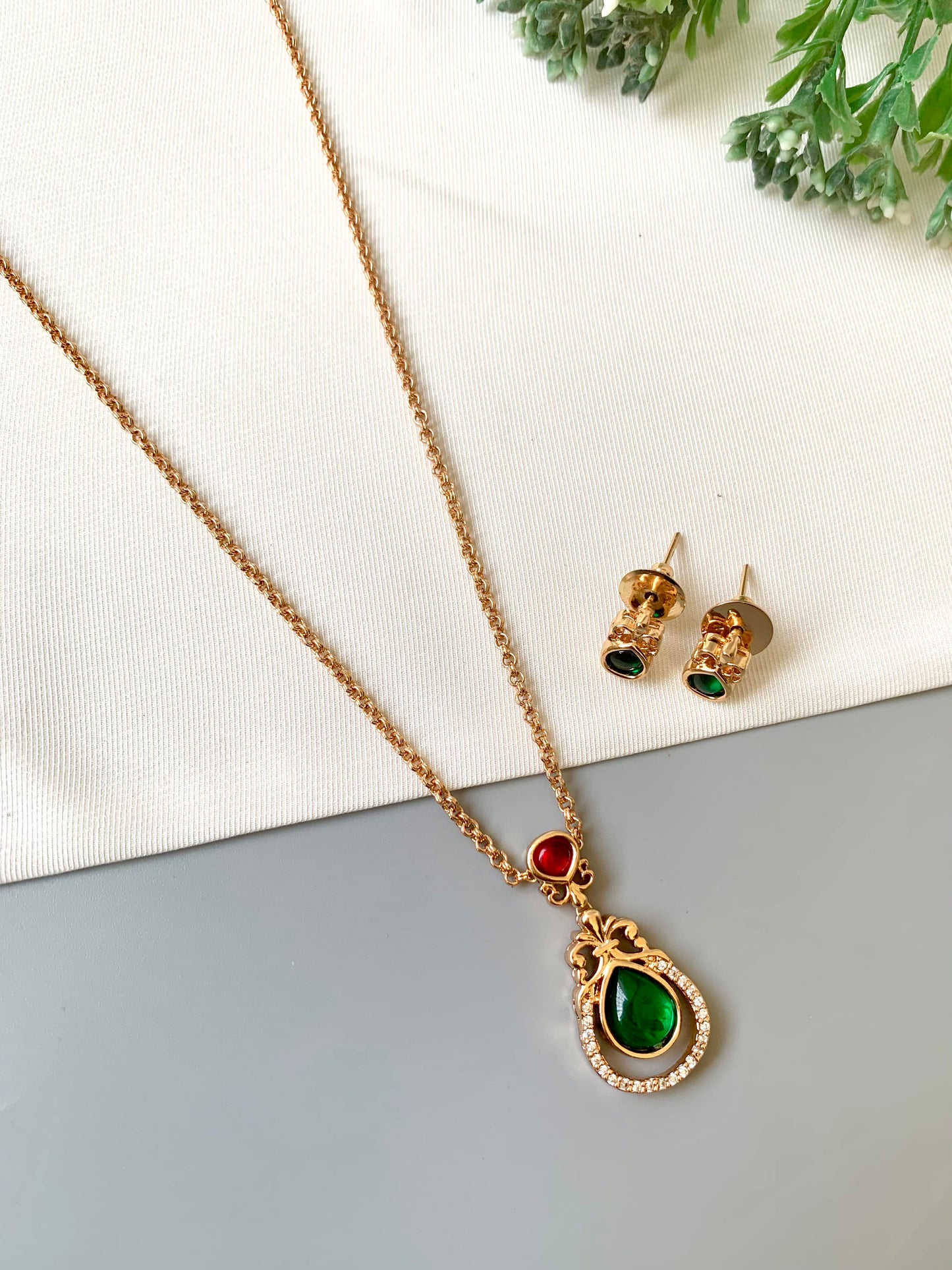 Handcrafted Lyana Pendant Set in 22kt Victorian rose gold plating with Semi-Precious Ruby, Emerald, and American Diamonds — includes chain, pendant, and studs by Zamal Jewels.