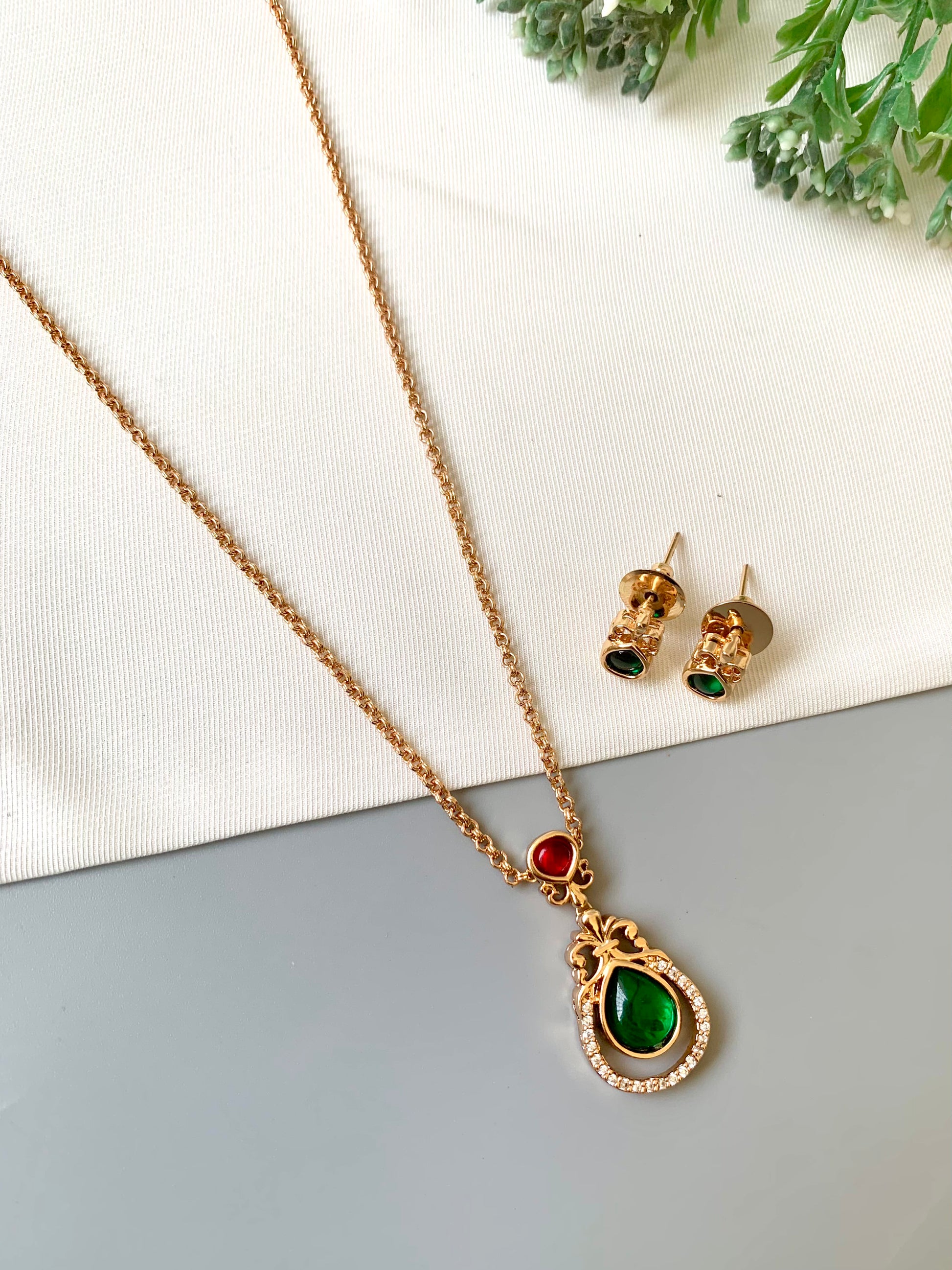 Handcrafted Lyana Pendant Set in 22kt Victorian rose gold plating with Semi-Precious Ruby, Emerald, and American Diamonds — includes chain, pendant, and studs by Zamal Jewels.