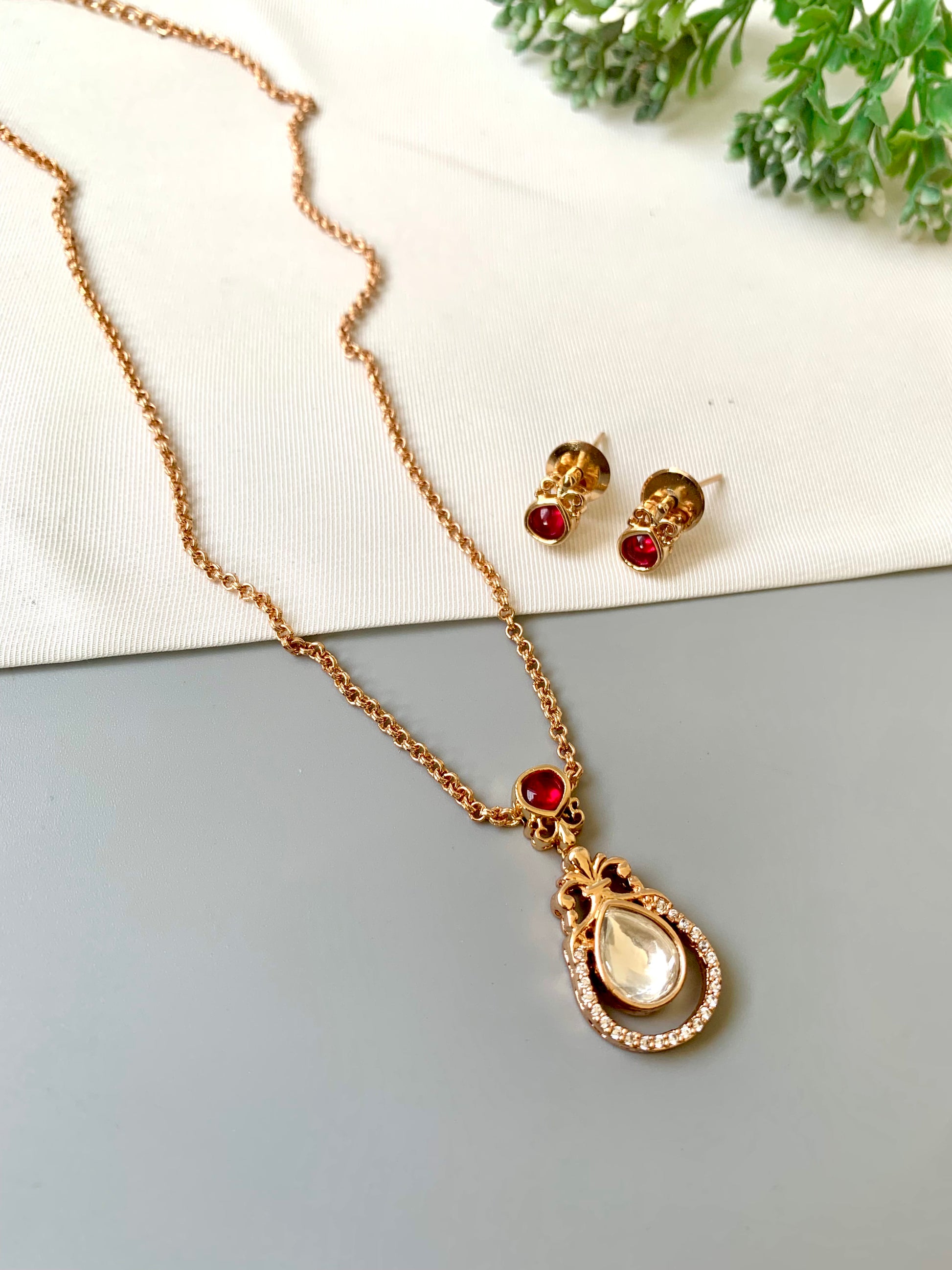 Handcrafted Lyana Pendant Set in 22kt Victorian rose gold plating with Semi-Precious Ruby and American Diamonds — includes chain, pendant, and studs by Zamal Jewels.
