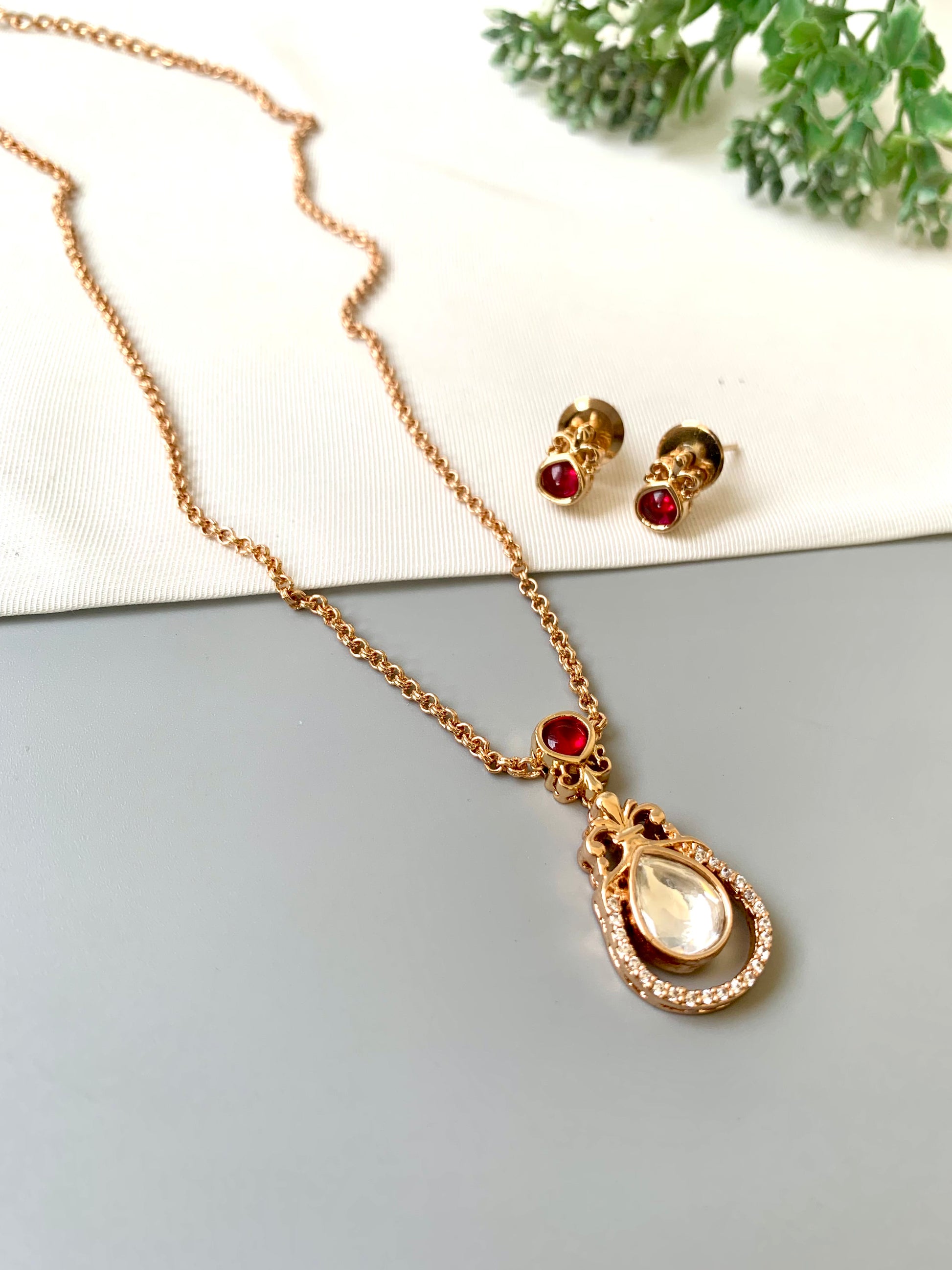 Handcrafted Lyana Pendant Set in 22kt Victorian rose gold plating with Semi-Precious Ruby and American Diamonds — includes chain, pendant, and studs by Zamal Jewels.