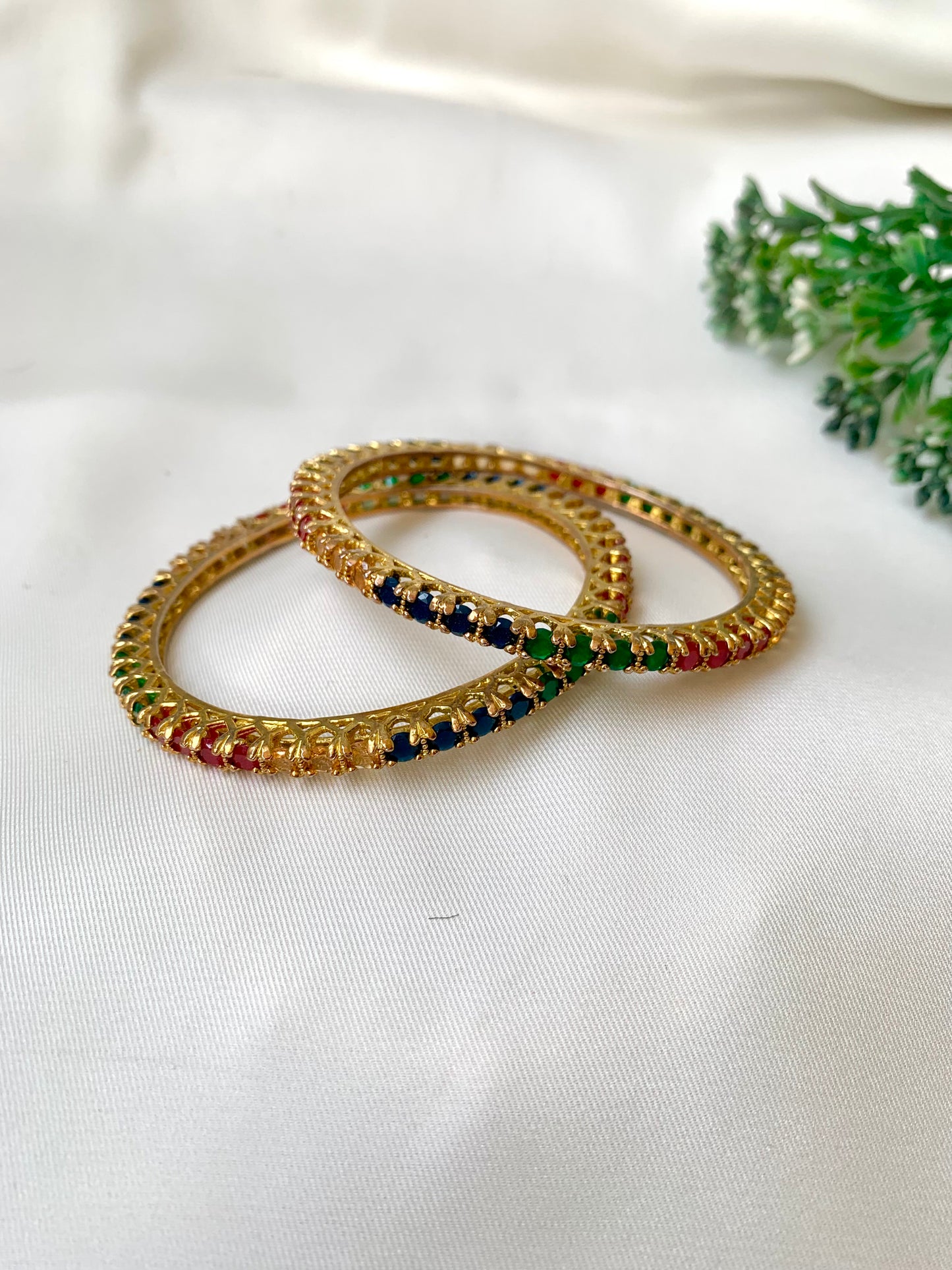 Handcrafted Neriah Bangles in 22kt gold plating with reverse Semi-Precious Ruby, Emerald, Sapphire, and Champagne stones — by Zamal Jewels.