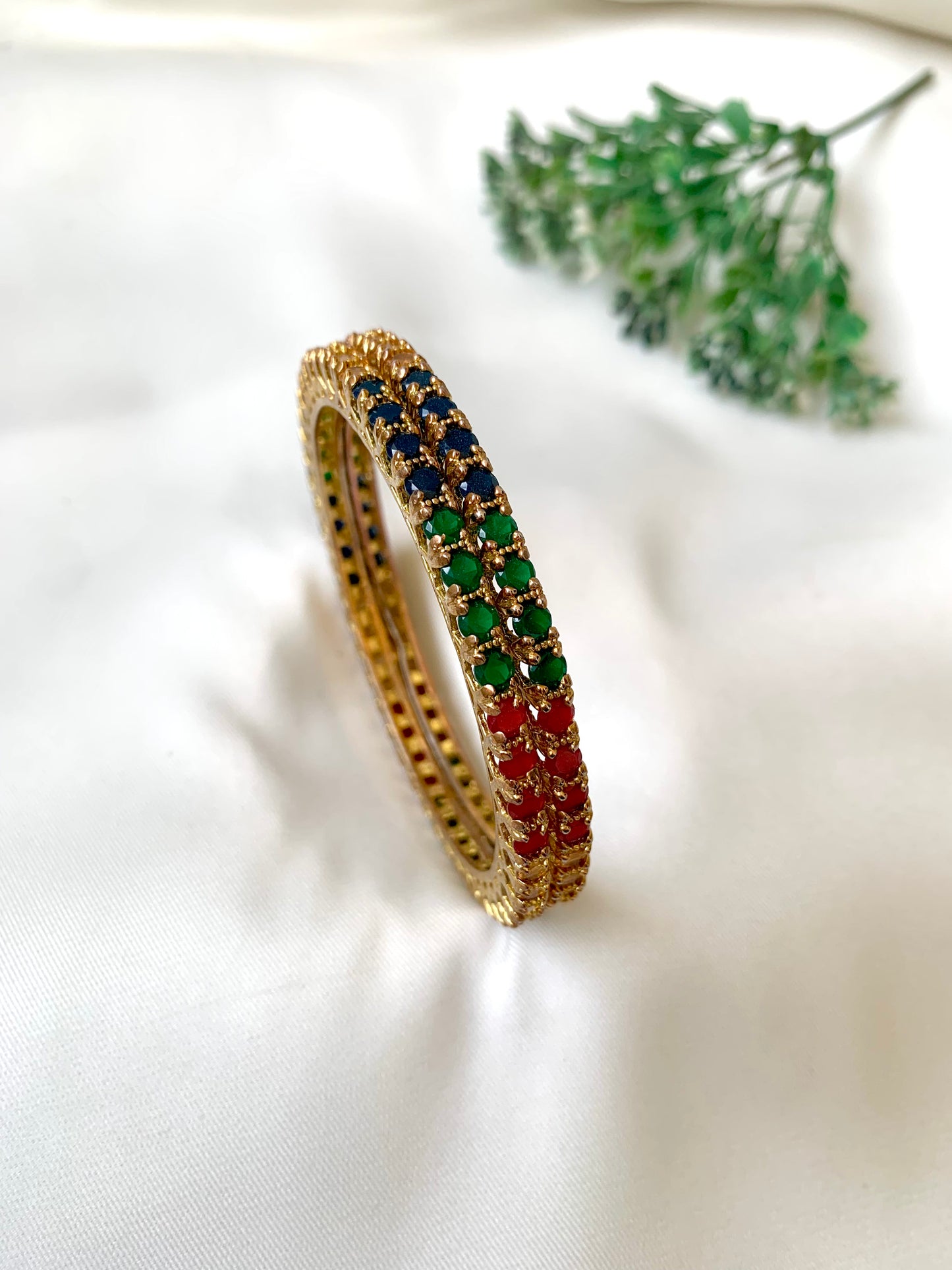 Handcrafted Neriah Bangles in 22kt gold plating with reverse Semi-Precious Ruby, Emerald, Sapphire, and Champagne stones — by Zamal Jewels.