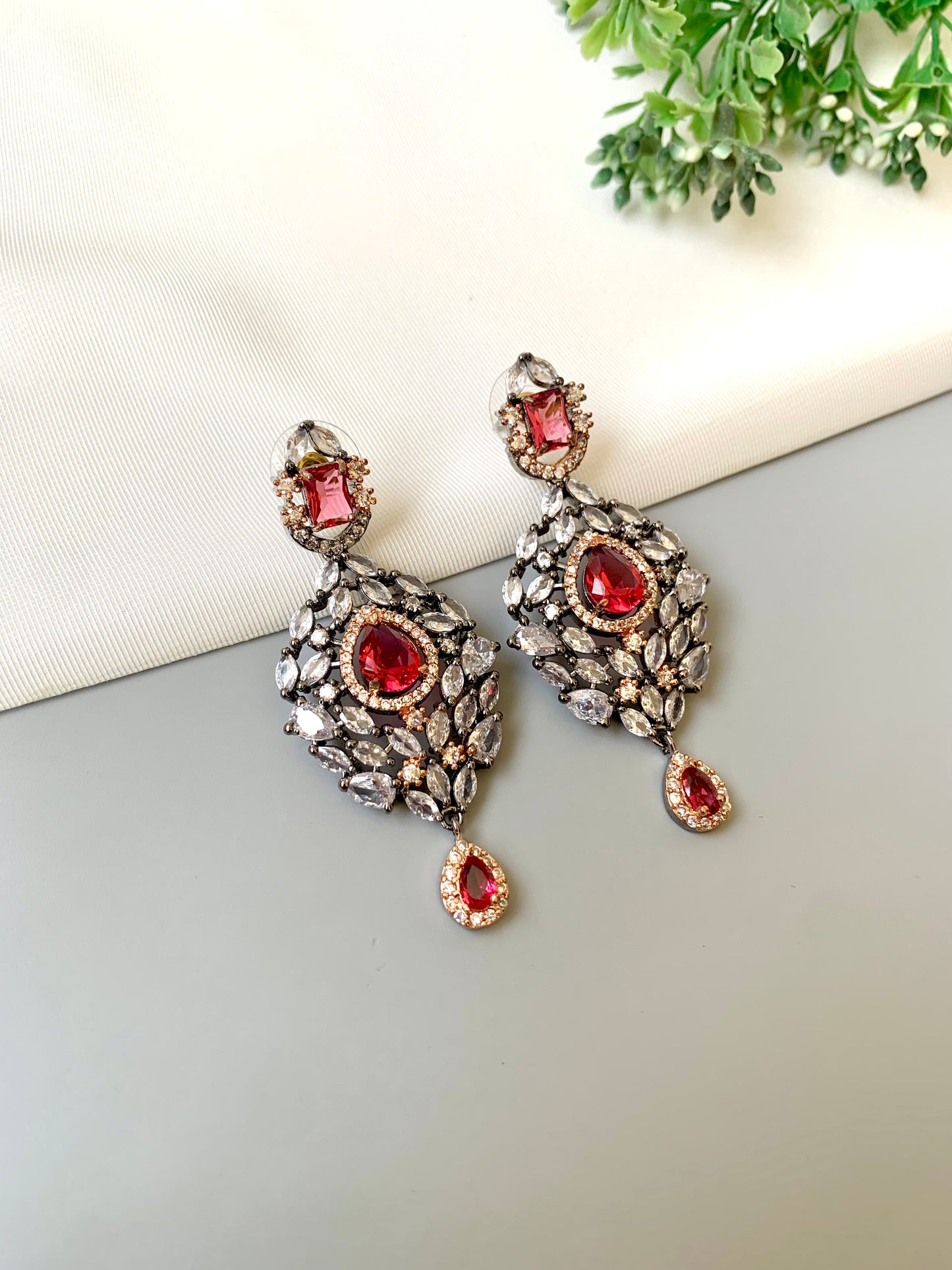 Handcrafted Noir Luxe Ruby Earrings in oxidized rose gold and rhodium plating with American Diamonds and semi-precious Ruby stones by Zamal Jewels.