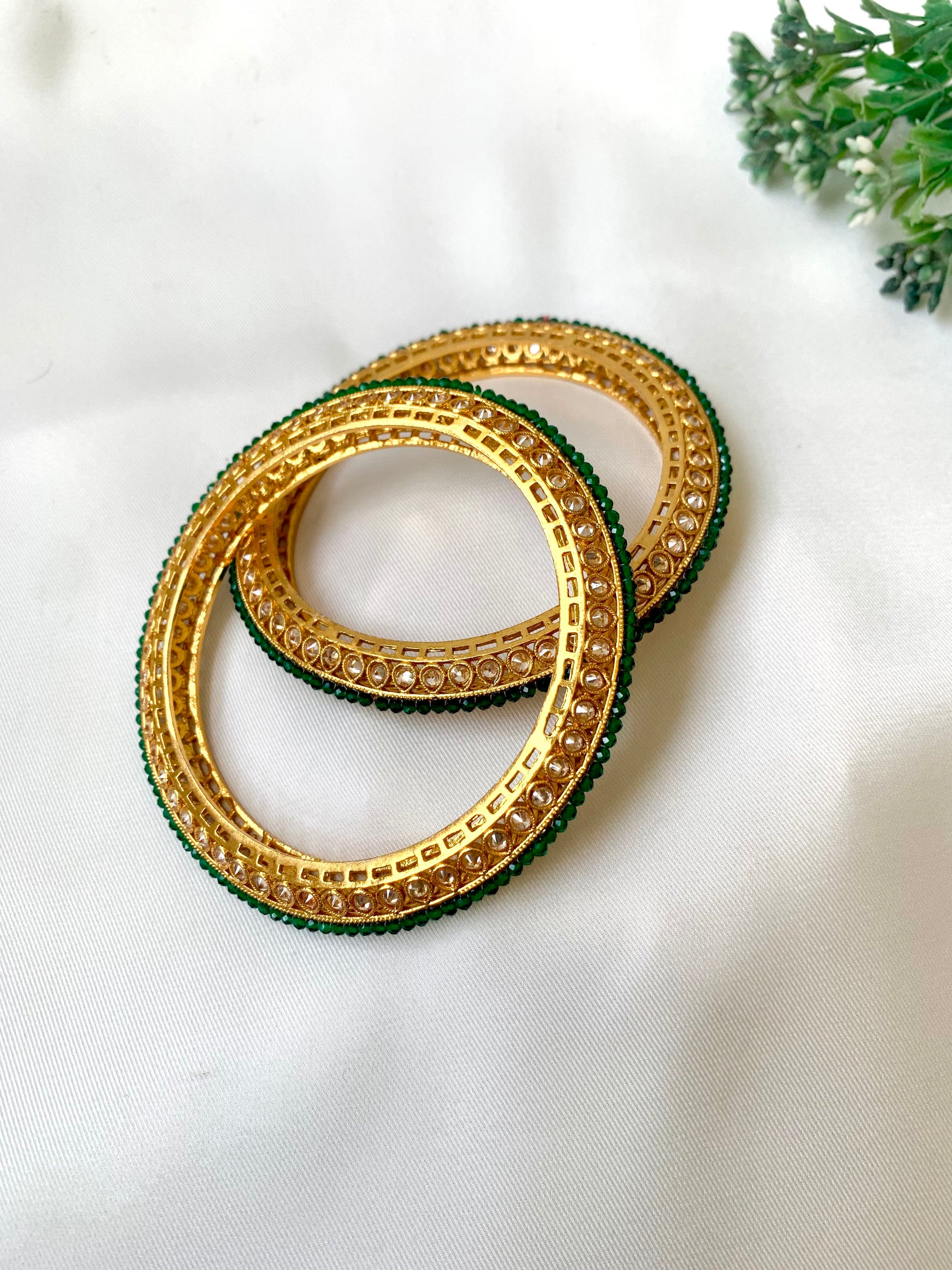 Handcrafted Ravira Bangles in 22kt gold plating with reverse American Diamonds and Semi-Precious Emeralds — by Zamal Jewels.