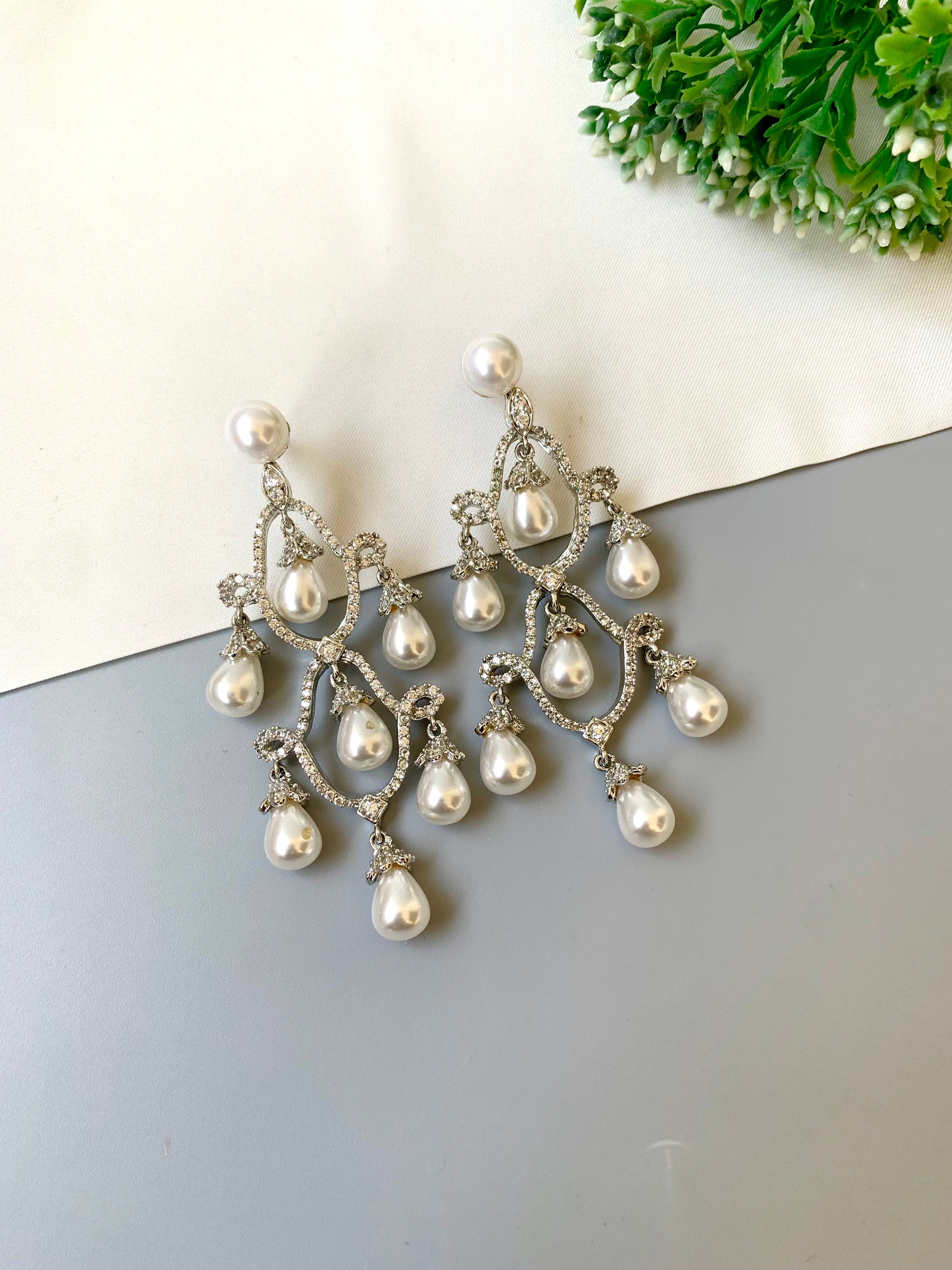 Hand crafted rhodium plated earrings with diamond finish, American diamonds and semi-precious pearl detailing by Zamal