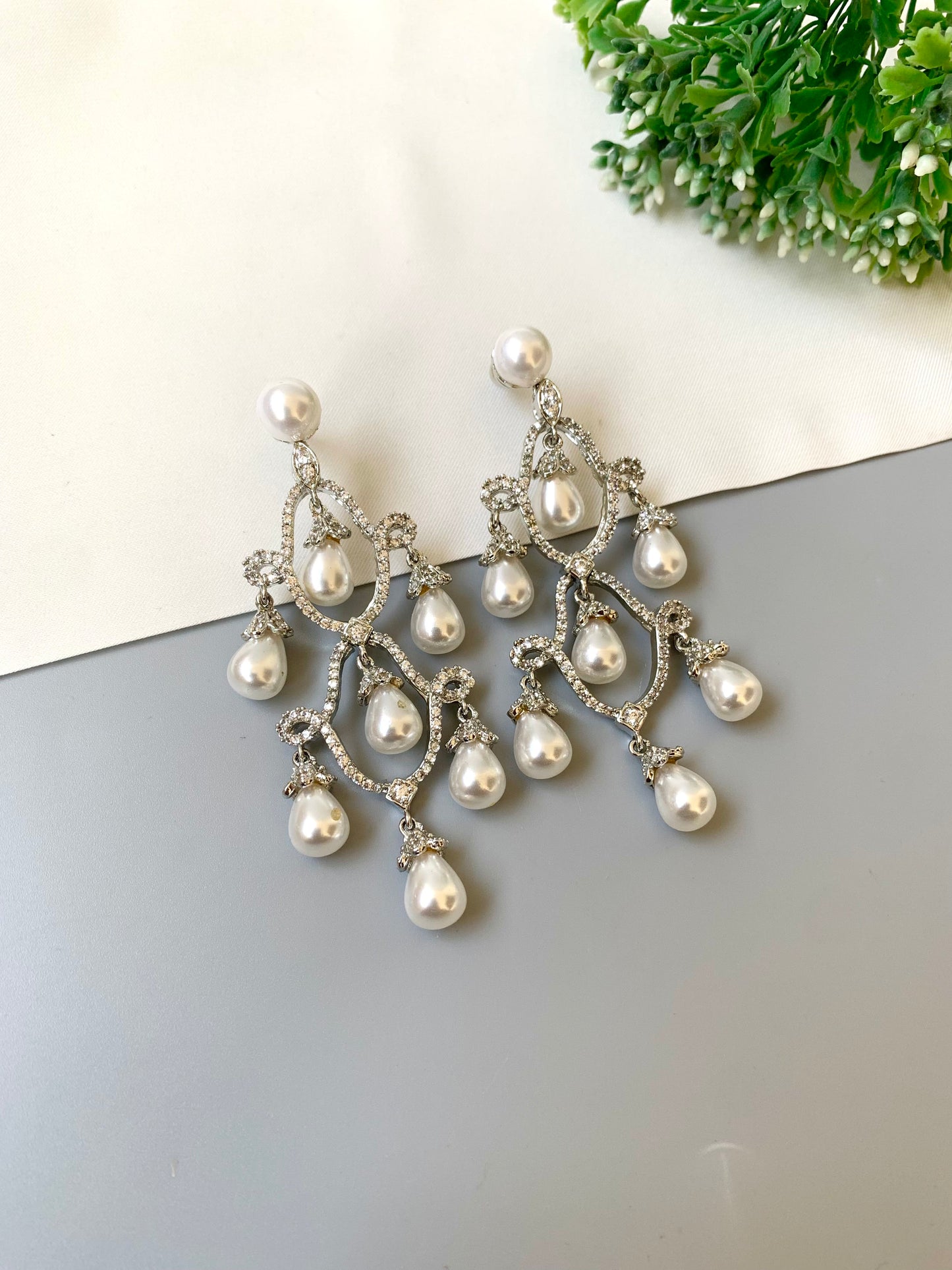 Hand crafted rhodium plated earrings with diamond finish, American diamonds and semi-precious pearl detailing by Zamal