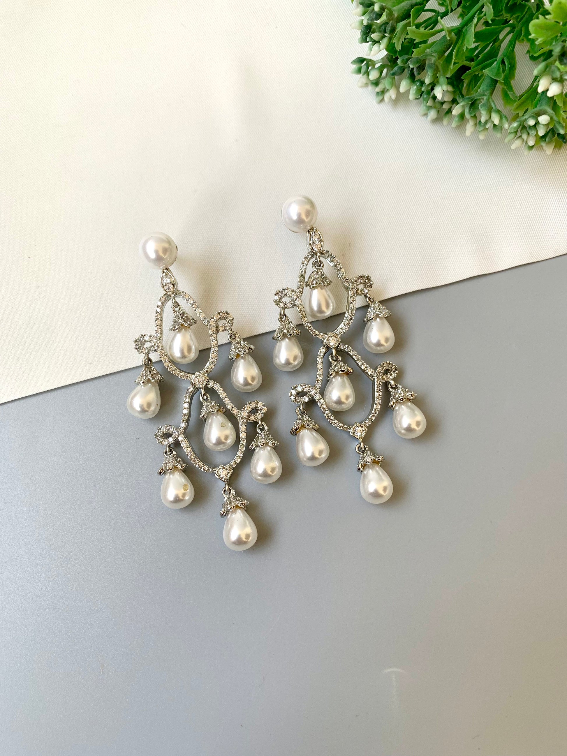 Pearl chandelier earrings on a gray surface with a light background