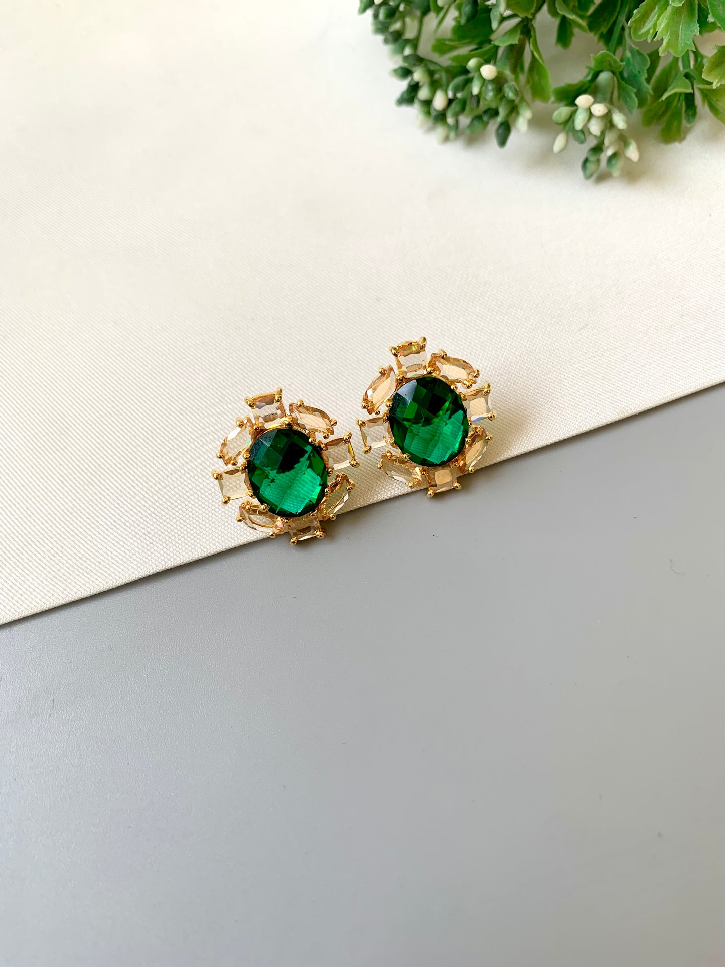 Handcrafted 22kt gold plated designer studs with reverse American diamonds emerald stones and Swarovski crystals