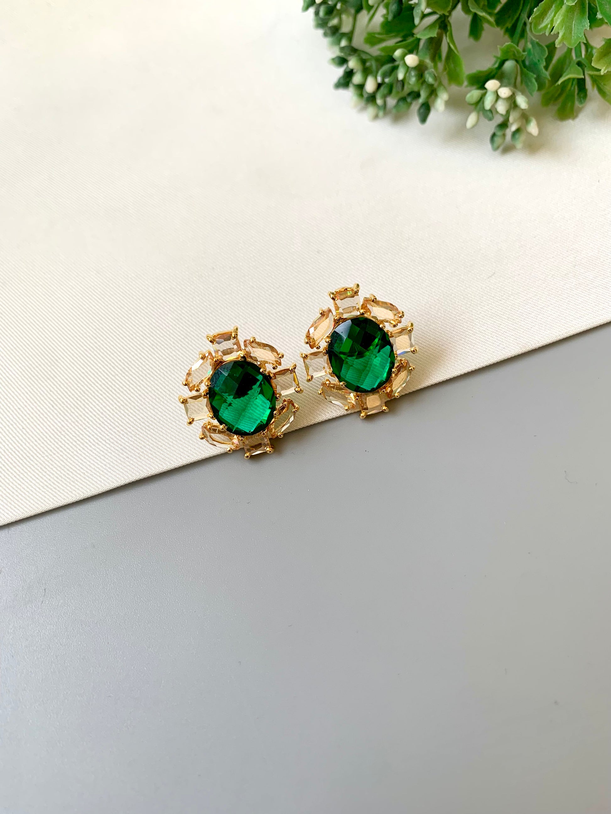Handcrafted 22kt gold plated designer studs with reverse American diamonds emerald stones and Swarovski crystals