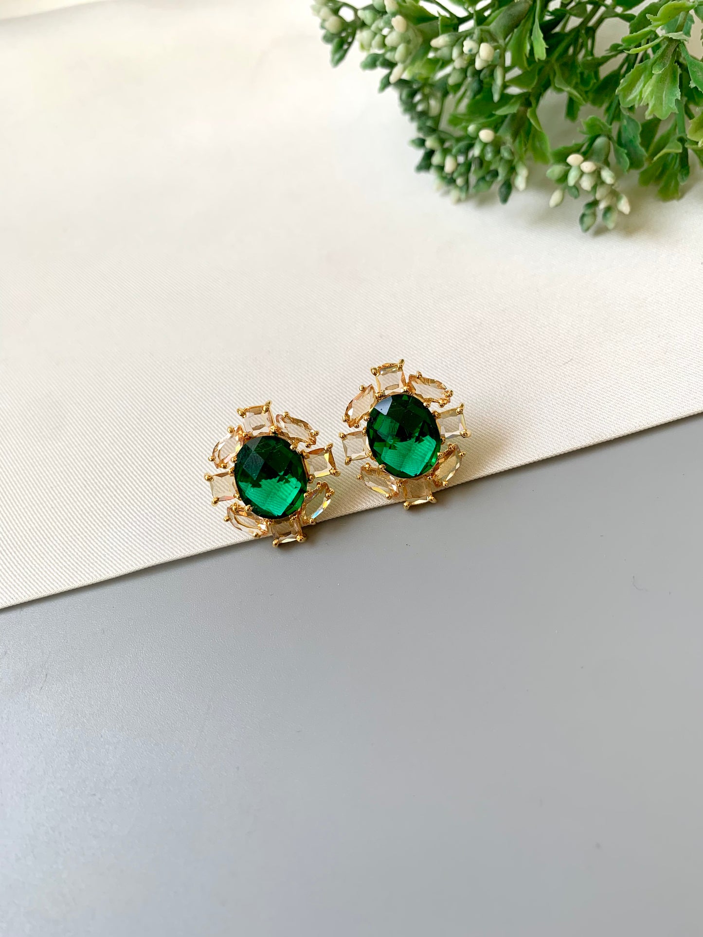 Handcrafted 22kt gold plated designer studs with reverse American diamonds emerald stones and Swarovski crystals
