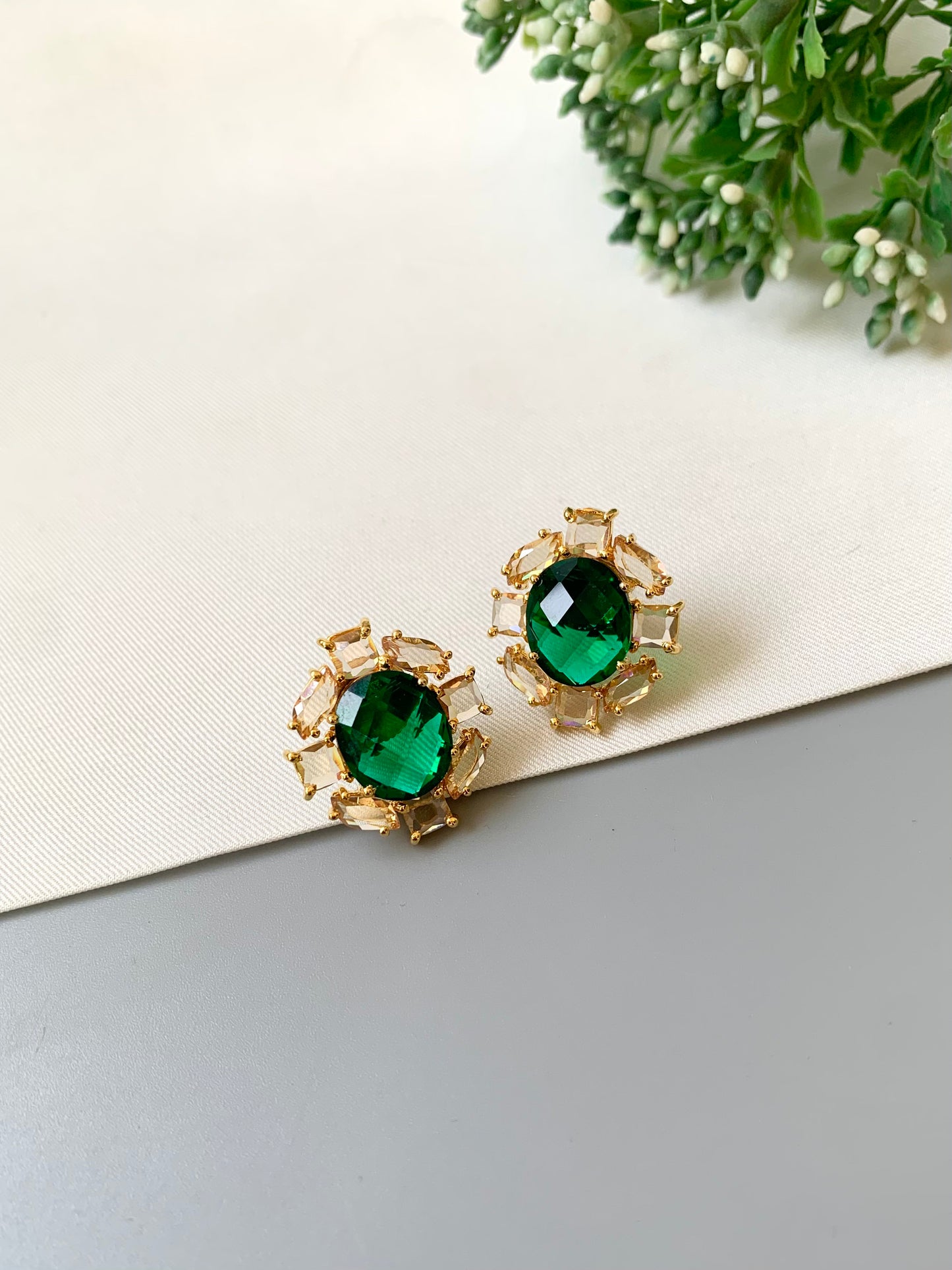 Handcrafted 22kt gold plated designer studs with reverse American diamonds emerald stones and Swarovski crystals