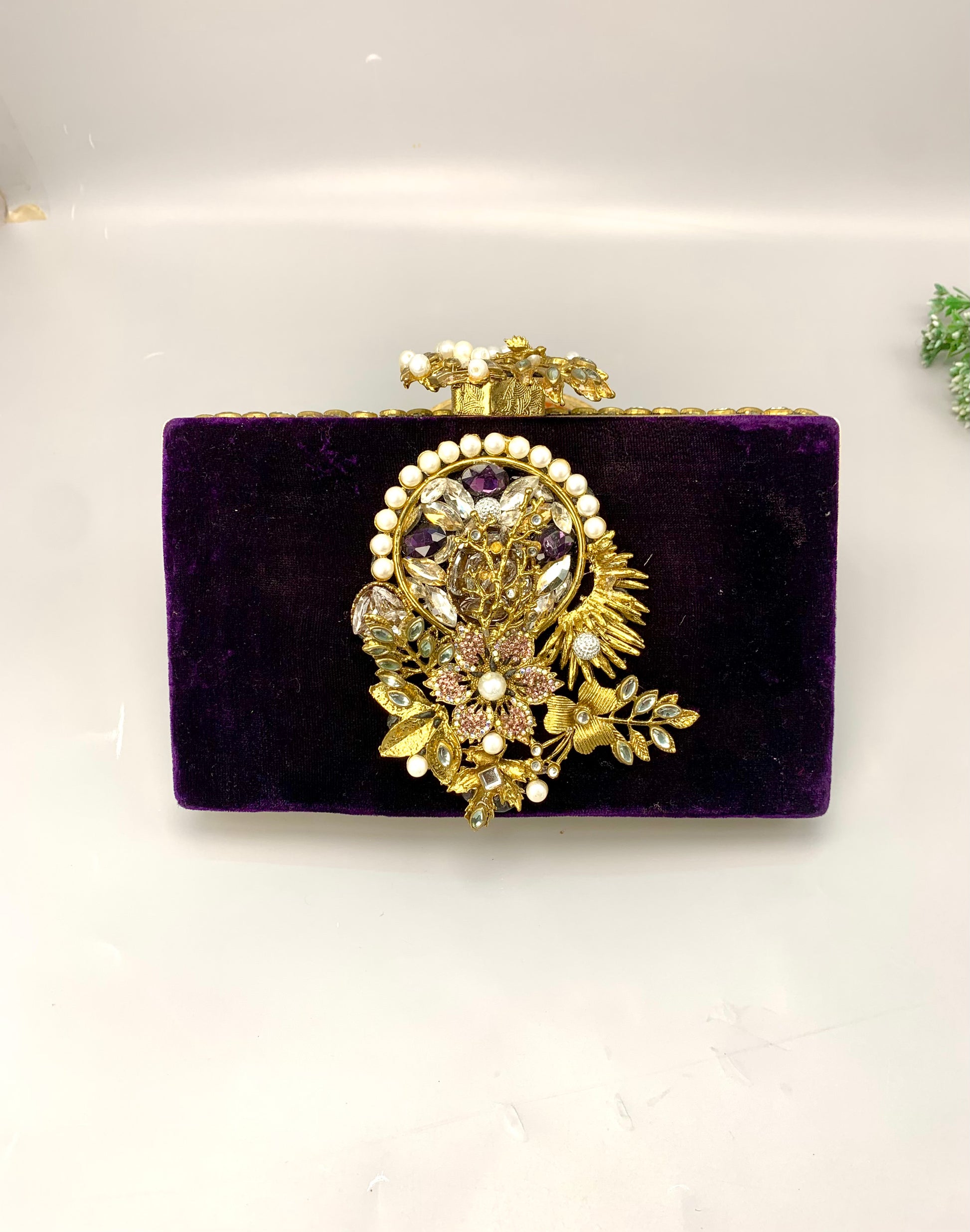 Zareen handcrafted gold plated clutch with kundan, American diamonds, pearls and gemstone embellishments