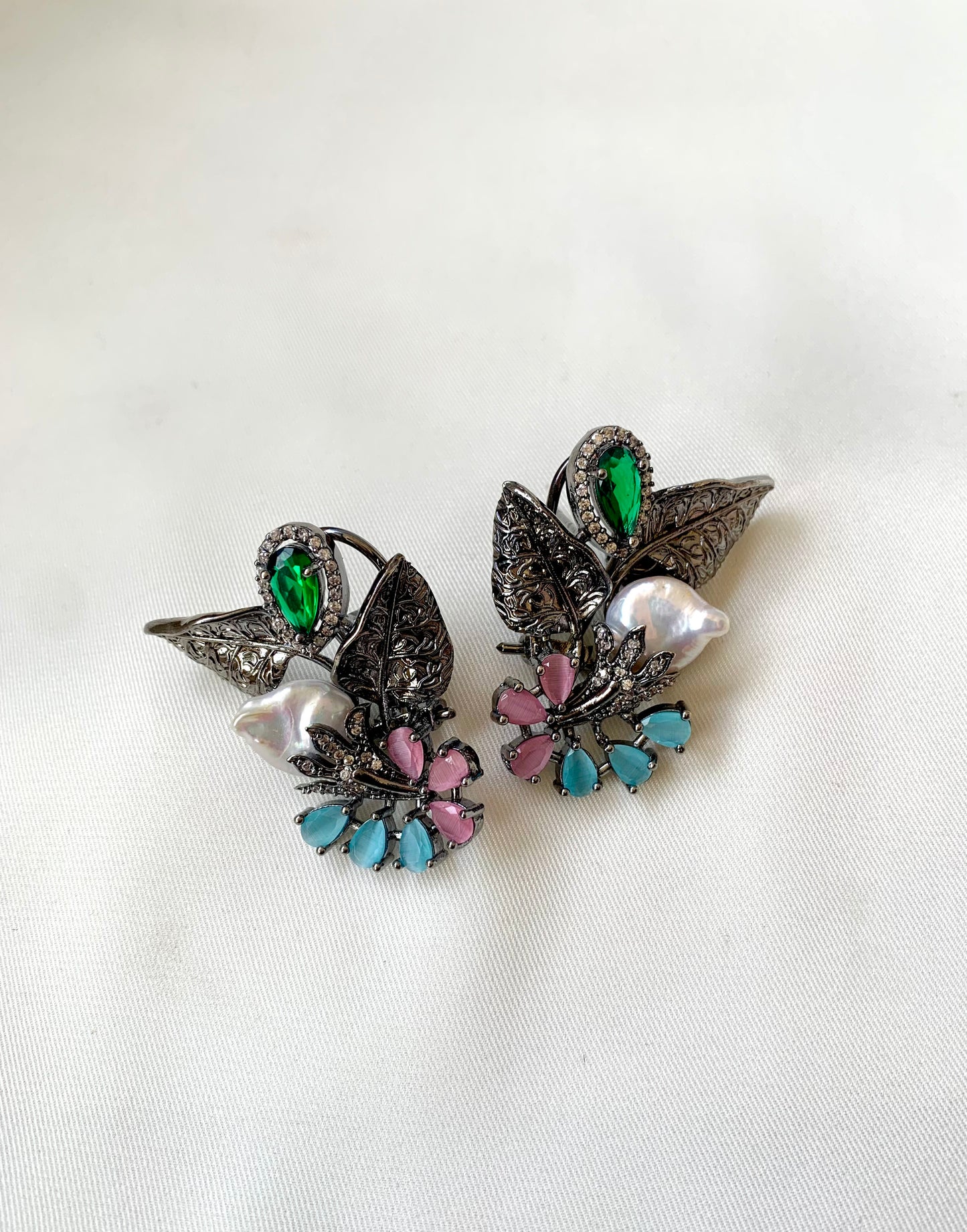 Pair of decorative earrings with gemstones on a white background