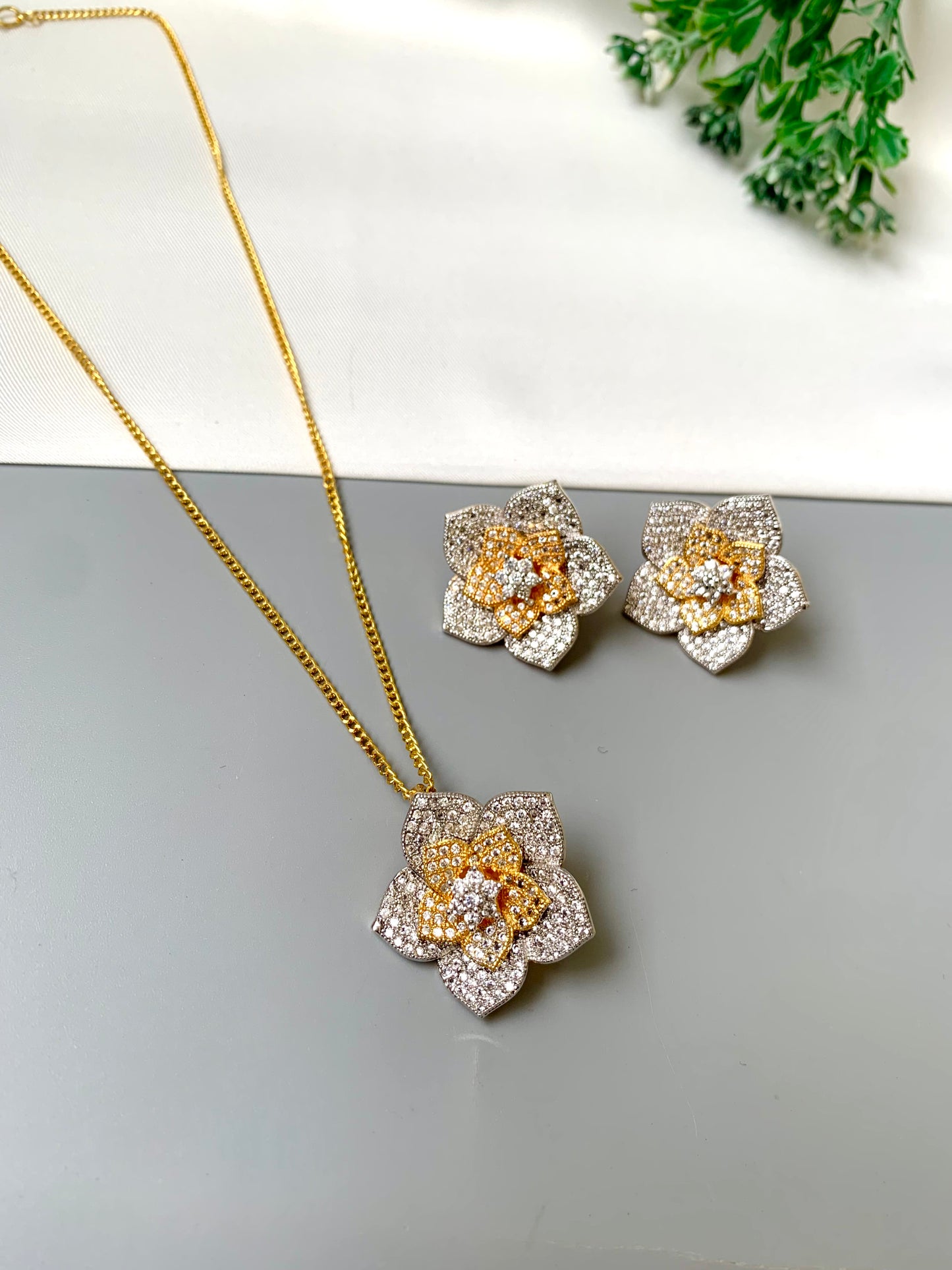 Zarwah floral pendant set in gold and rhodium plating with American diamonds and matching earrings