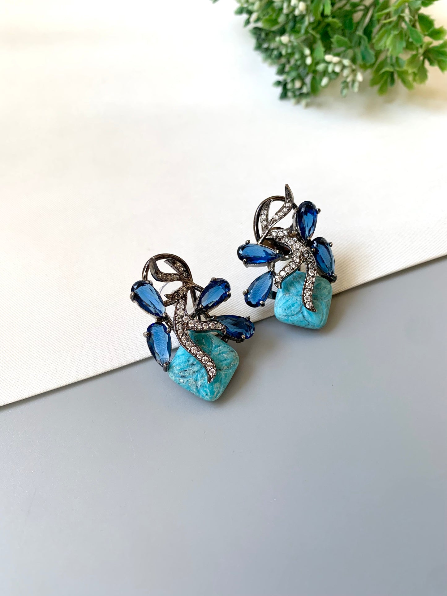 Hand crafted Zita Feroza studs in rhodium plating with oxidized polish, featuring American Diamonds, hand carved Feroza and Sapphire stones