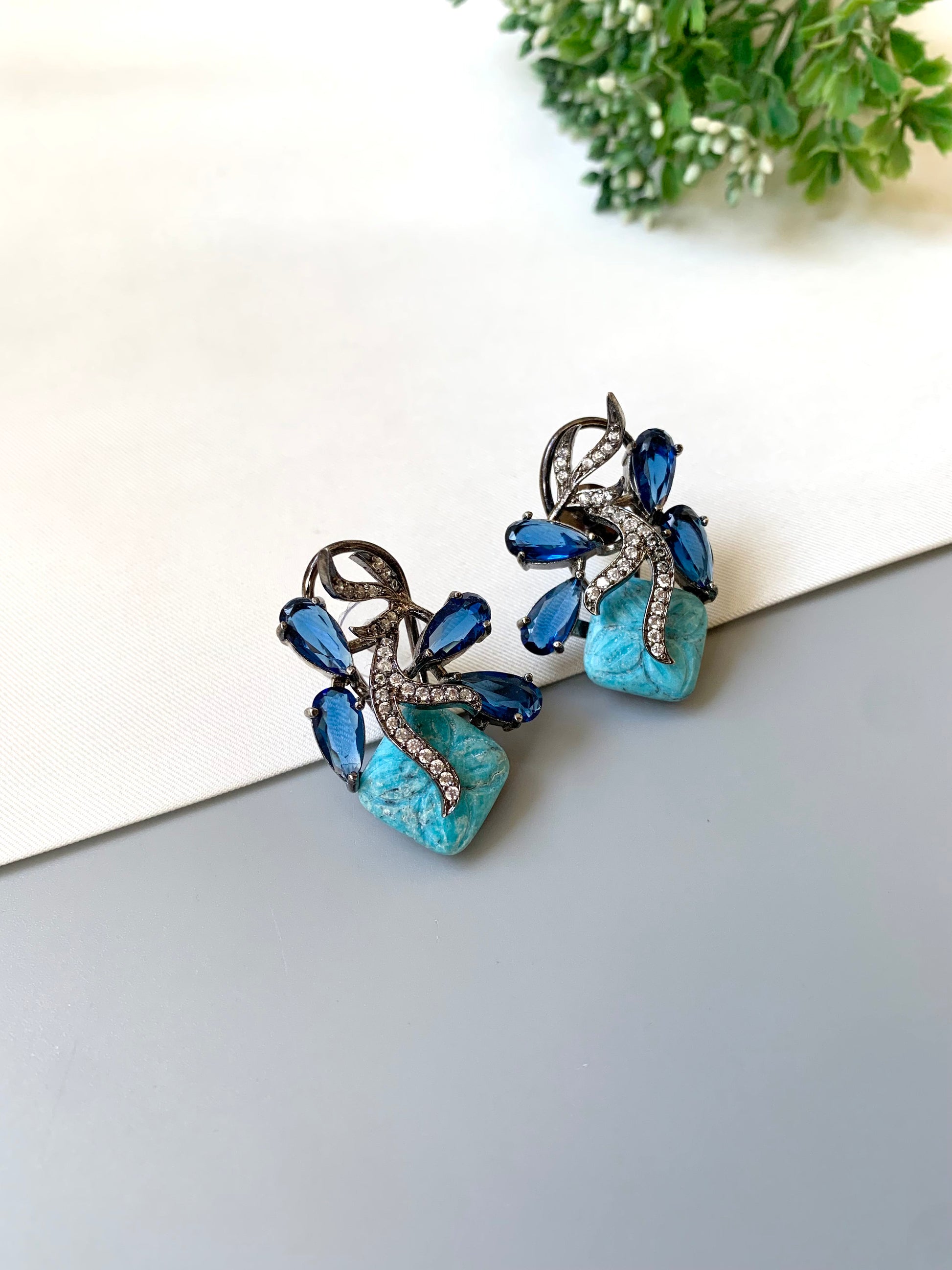 Hand crafted Zita Feroza studs in rhodium plating with oxidized polish, featuring American Diamonds, hand carved Feroza and Sapphire stones