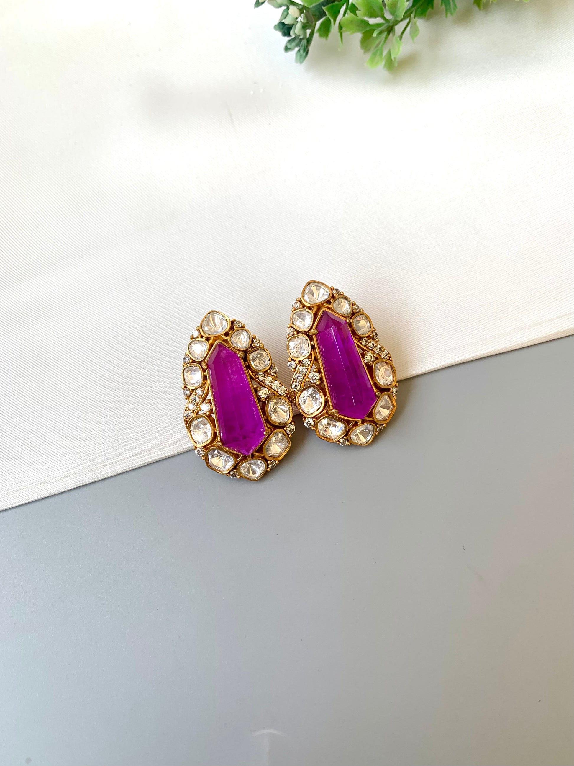 Pair of earrings with purple stones on a white surface