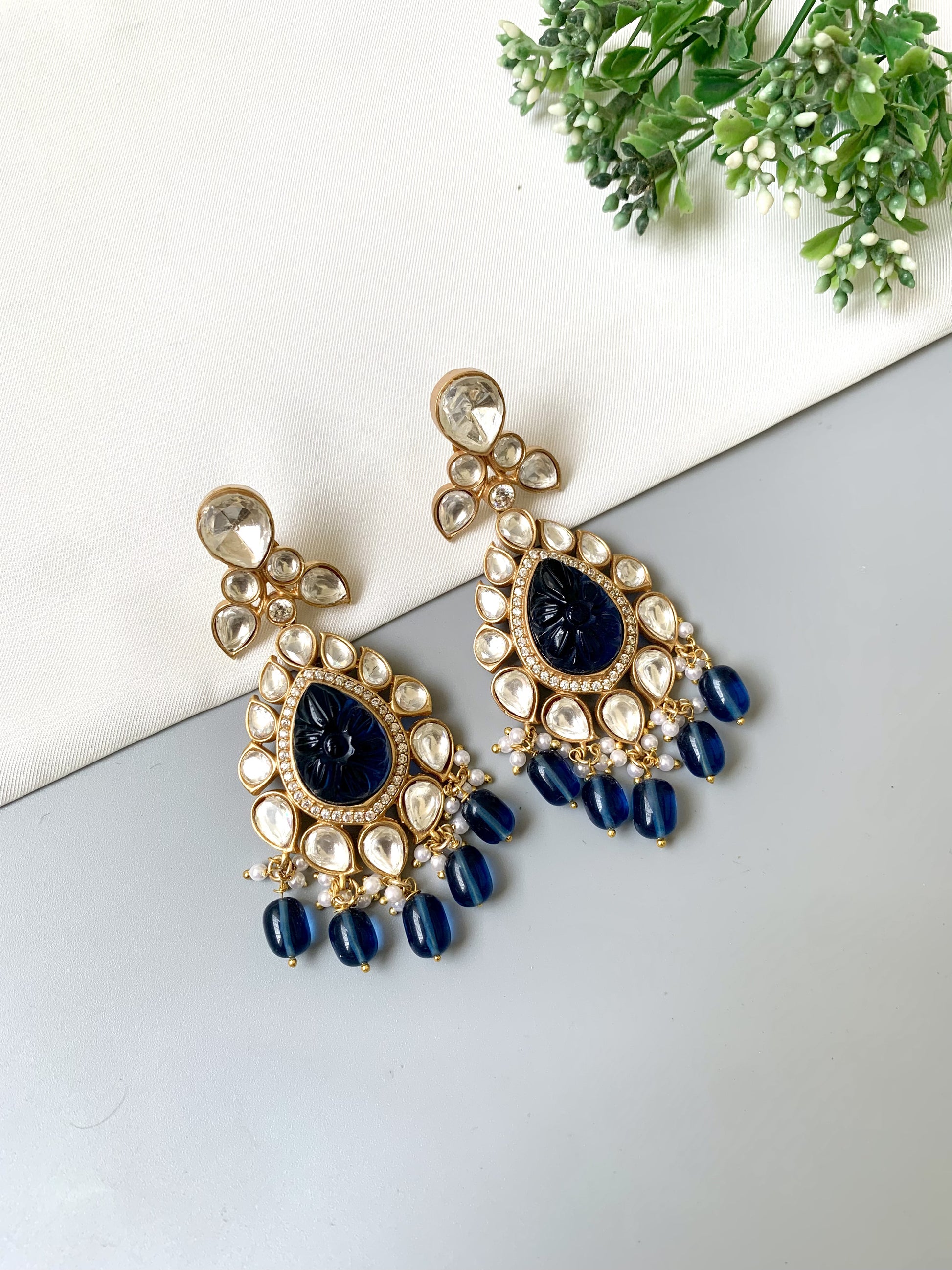 Close-up of Zoya earrings featuring Moissanite Kundan, sapphire centerpiece, and deep blue faceted beads